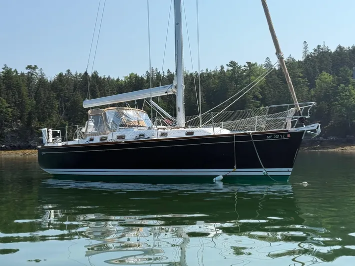 Dawn Treader Yacht Photos Pics Tartan 3700 Keel/Centerboard sailboat from 2005 on calm water, forested background.