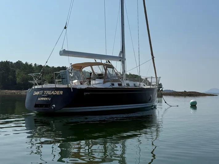 Dawn Treader Yacht Photos Pics Sailboat Tartan 3700 Keel/Centerboard 2005 moored on calm water near forested shore.