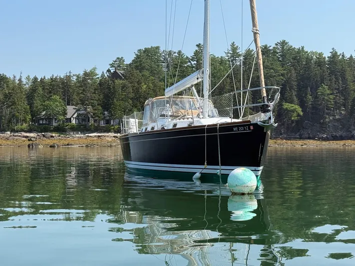 Dawn Treader Yacht Photos Pics Tartan 3700 Keel/Centerboard sailboat from 2005 moored in a serene, wooded bay.