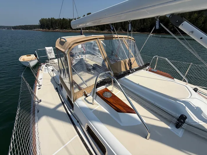 Dawn Treader Yacht Photos Pics 2005 Tartan 3700 Keel/Centerboard sailboat on calm water, featuring a tan canopy and sleek design.