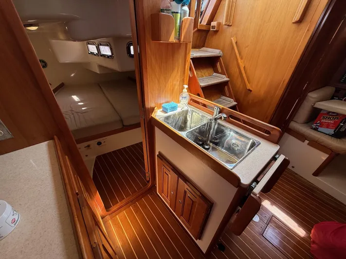 Dawn Treader Yacht Photos Pics Interior of 2005 Tartan 3700 Keel/Centerboard sailboat with wooden finishes and compact kitchen.