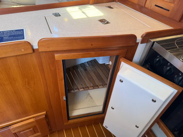 Dawn Treader Yacht Photos Pics Wooden interior of 2005 Tartan 3700 Keel/Centerboard with open fridge and stove.