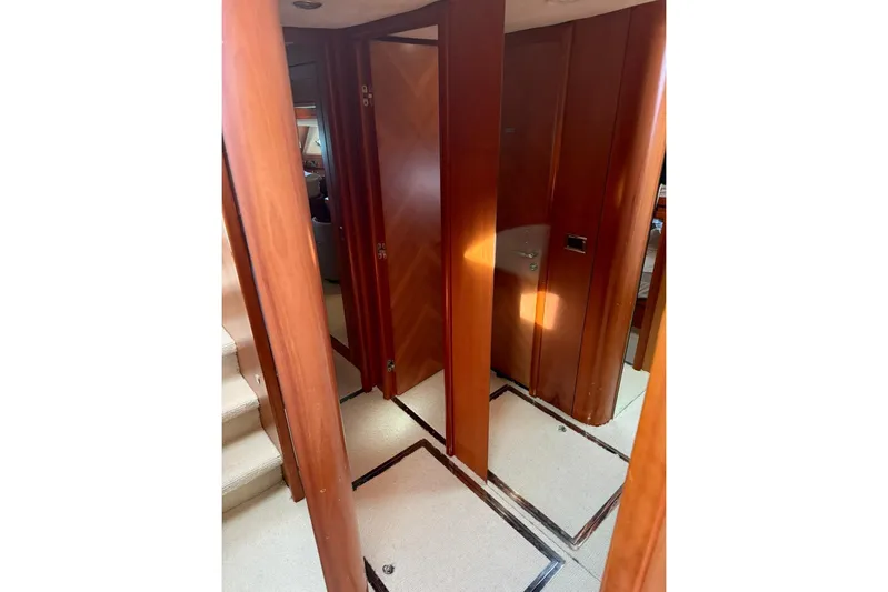  Yacht Photos Pics Interior hallway of 2006 Sunseeker Predator 82 yacht with wooden doors and carpeted floor.