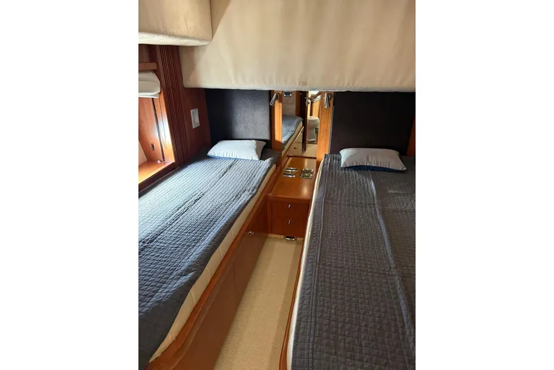  Yacht Photos Pics Twin beds in a 2006 Sunseeker Predator 82 yacht cabin, featuring wood accents and blue bedding.