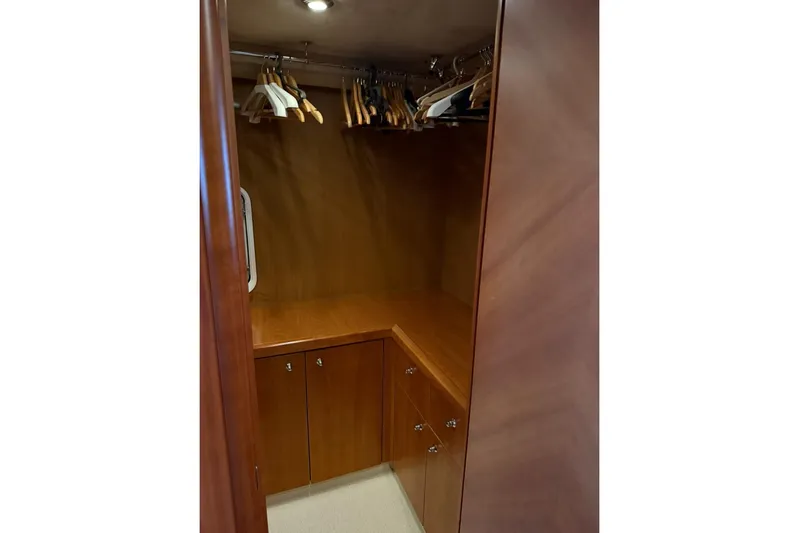 Yacht Photos Pics Wooden closet interior with hangers, cabinets, and lighting on a 2006 Sunseeker Predator 82 yacht.