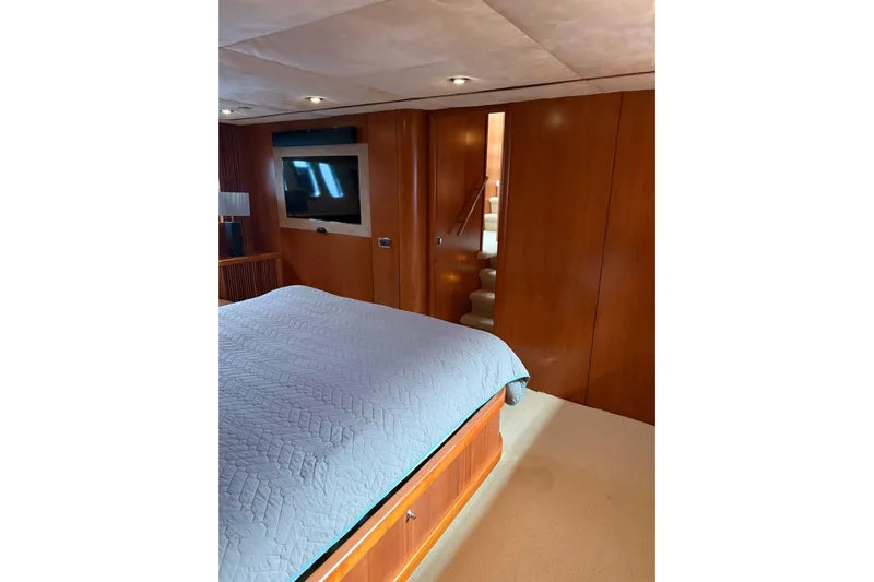  Yacht Photos Pics Luxurious bedroom interior of 2006 Sunseeker Predator 82 yacht with TV and wooden paneling.