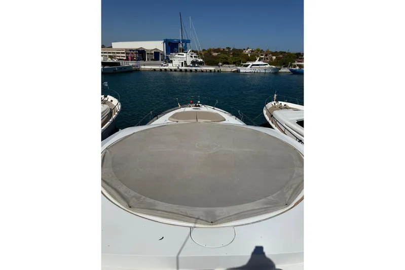  Yacht Photos Pics 2006 Sunseeker Predator 82 yacht docked at marina, clear blue sky, calm waters.