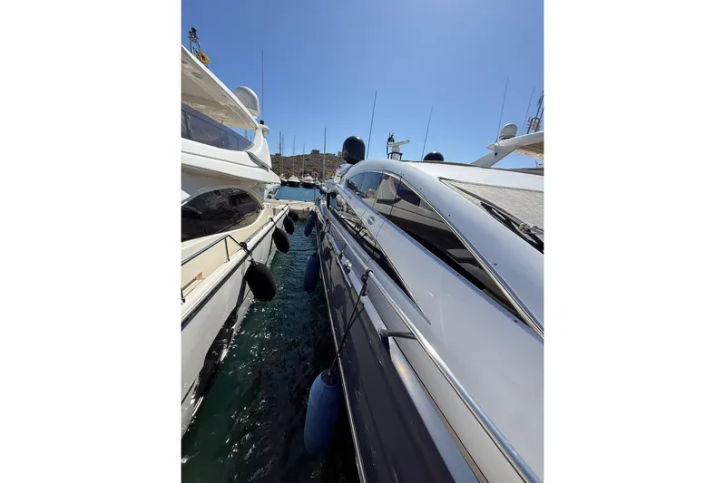  Yacht Photos Pics 2006 Sunseeker Predator 82 yacht docked beside another vessel under clear blue sky.