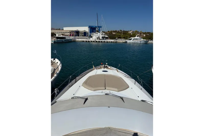  Yacht Photos Pics 2006 Sunseeker Predator 82 yacht docked at marina, clear blue sky, calm waters.