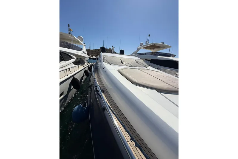  Yacht Photos Pics 2006 Sunseeker Predator 82 yacht docked alongside other boats under clear sky.