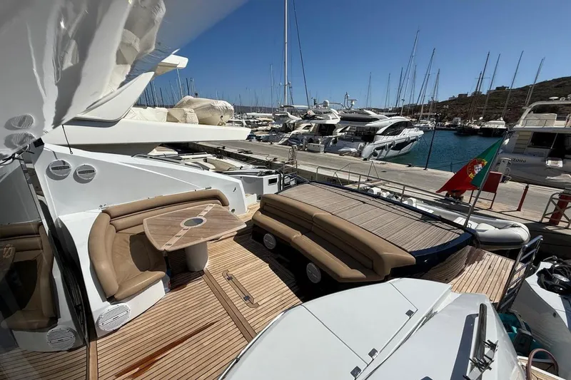  Yacht Photos Pics Luxurious 2006 Sunseeker Predator 82 yacht docked, featuring elegant seating and a Portuguese flag.
