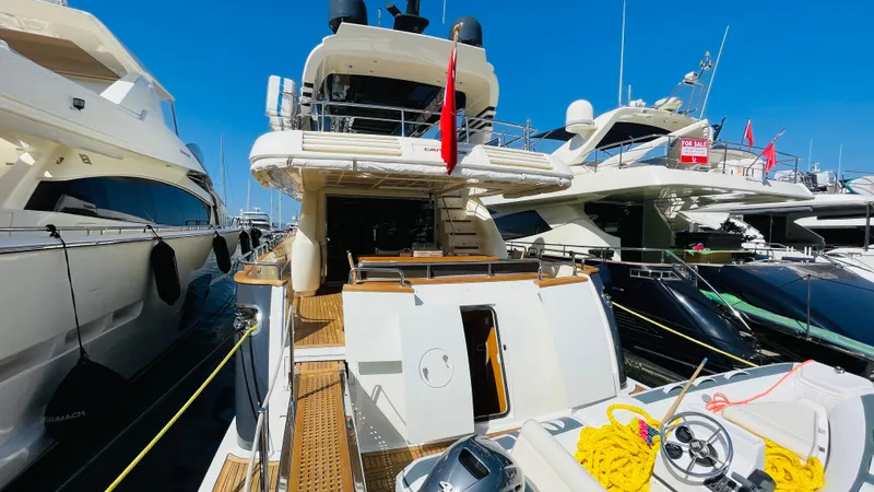  Yacht Photos Pics Luxury Canados 76 yacht, 2016 model, docked among other boats under clear blue sky.