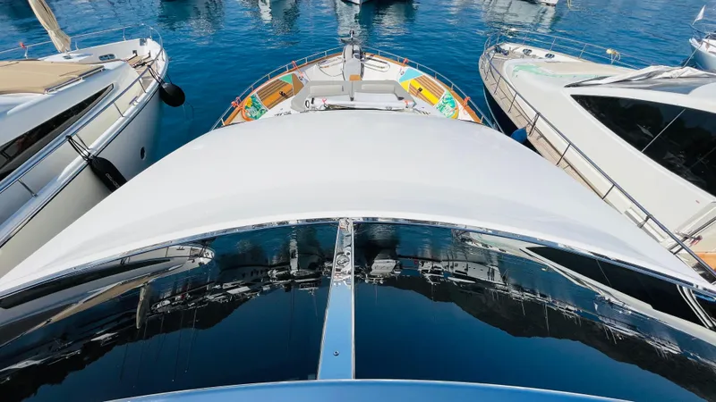  Yacht Photos Pics Luxury Canados 76 yacht from 2016 docked among other boats in a marina.
