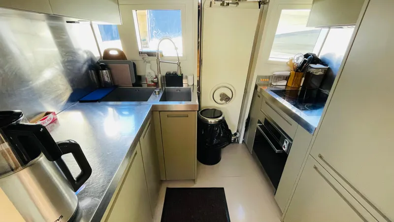  Yacht Photos Pics Modern kitchen interior on a 2016 Canados 76 yacht, featuring stainless steel countertops.