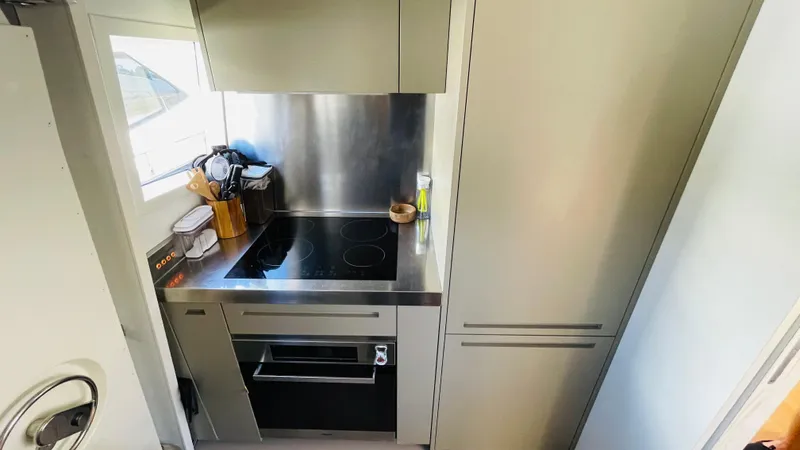  Yacht Photos Pics Compact kitchen in a 2016 Canados 76 yacht with modern appliances and sleek design.