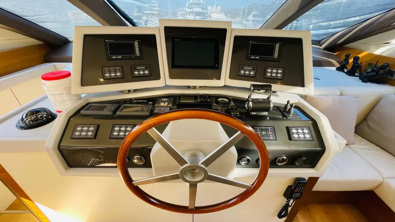  Yacht Photos Pics Helm of 2016 Canados 76 yacht with wooden steering wheel and modern navigation controls.