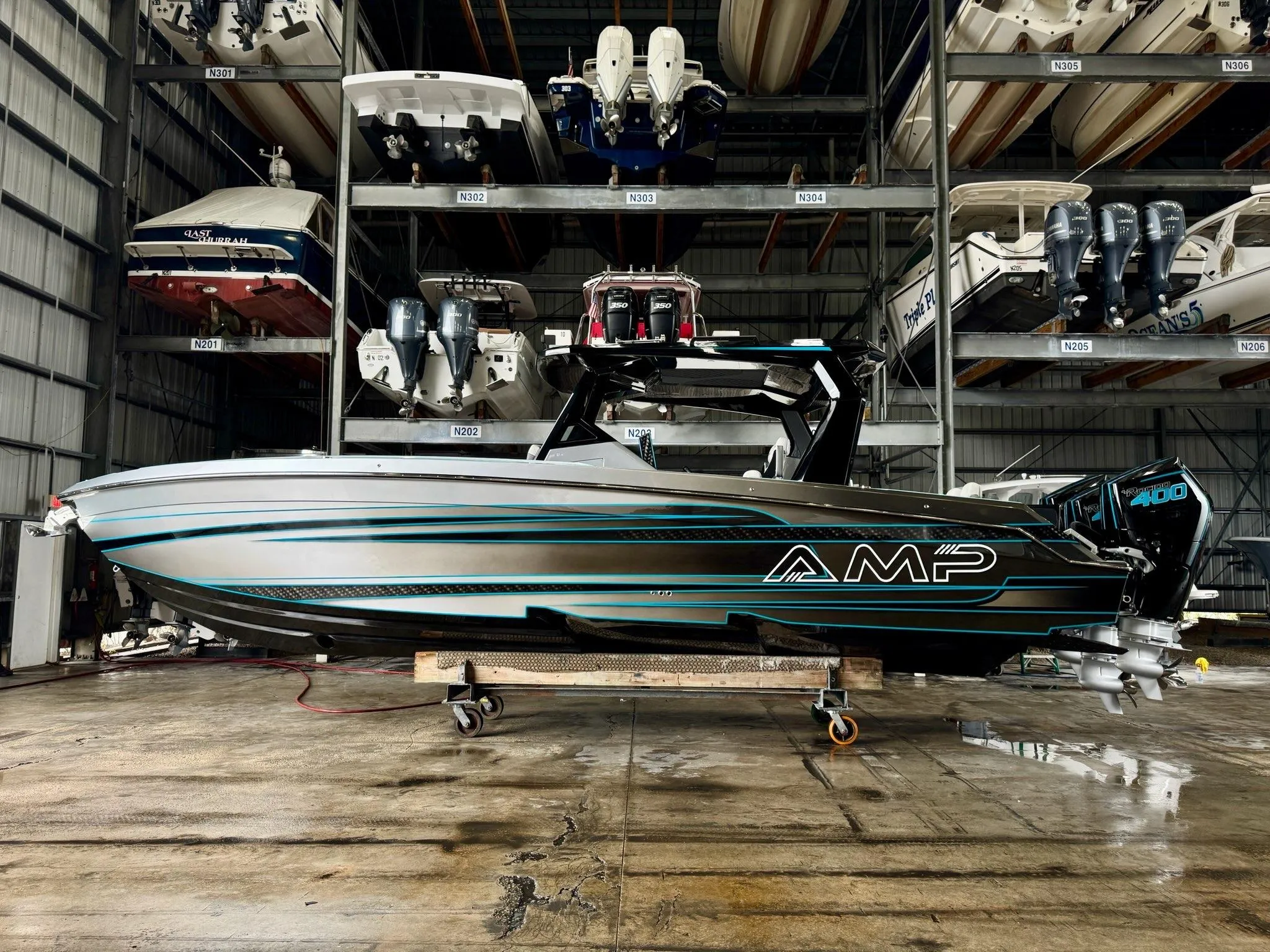 2024 AMP 333 speedboat in storage, showcasing sleek design and powerful engine.