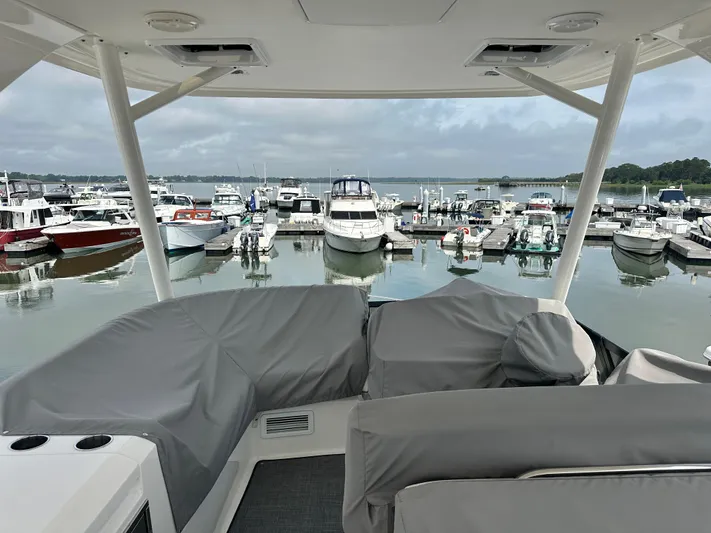 Finally Yacht Photos Pics 2021 Tiara Yachts F44 Flybridge at marina, covered seating, overlooking docked boats.