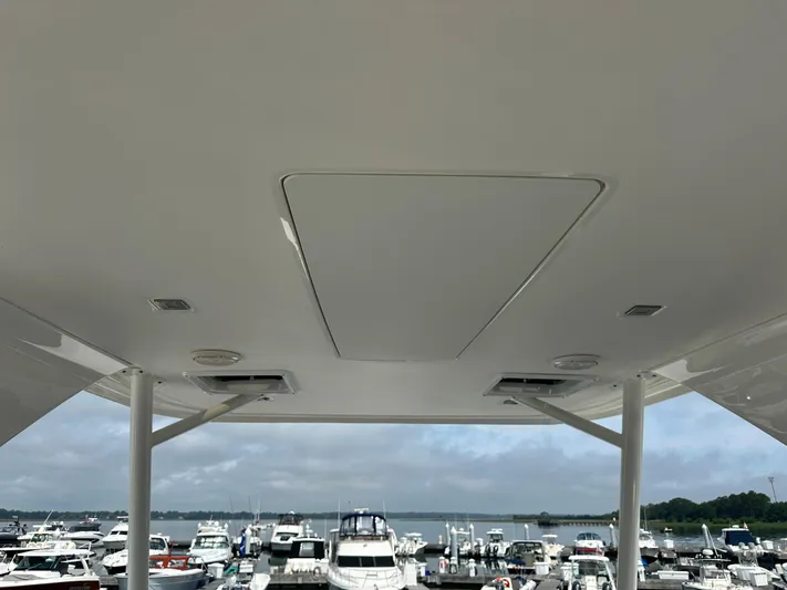 Finally Yacht Photos Pics Tiara Yachts 2021 F44 Flybridge ceiling view at marina with boats in background.