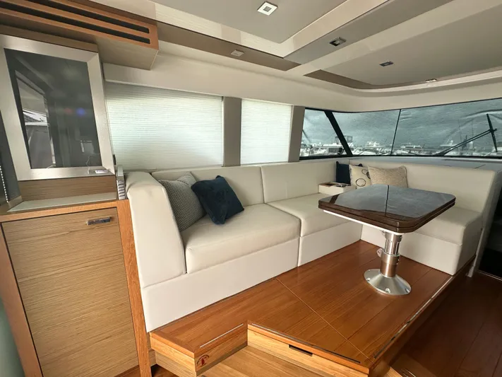 Finally Yacht Photos Pics Luxurious interior of 2021 Tiara Yachts F44 Flybridge with white seating and wooden accents.