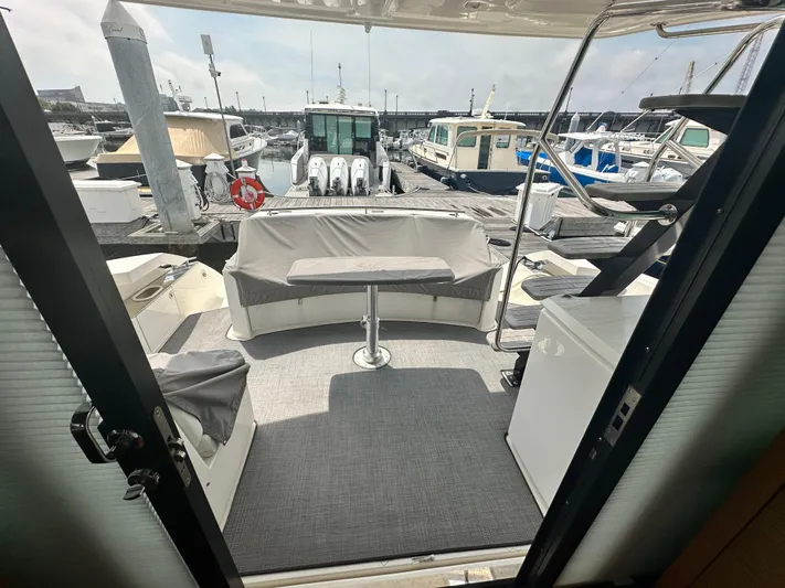 Finally Yacht Photos Pics 2021 Tiara Yachts F44 Flybridge, rear deck view with seating, docked at marina.