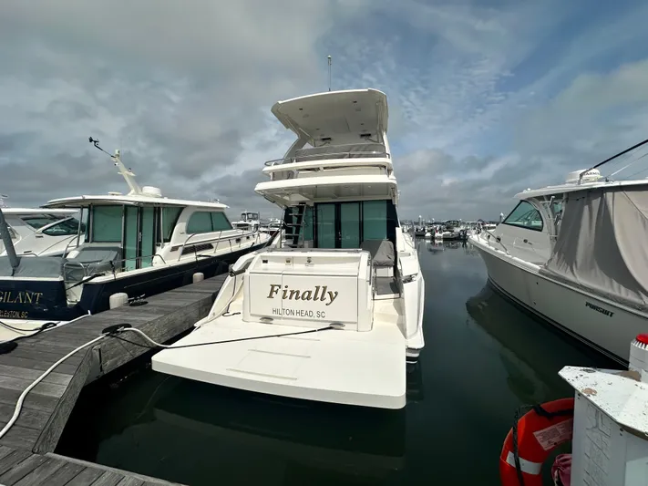 Finally Yacht Photos Pics 2021 Tiara Yachts F44 Flybridge docked, rear view, overcast sky, marina setting.