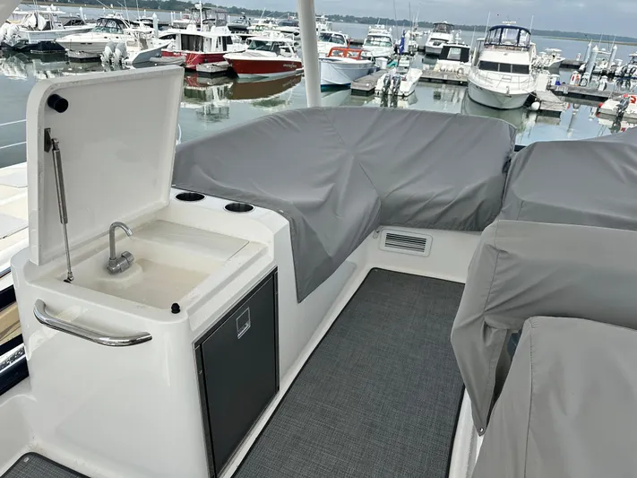 Finally Yacht Photos Pics 2021 Tiara Yachts F44 Flybridge with covered seating and sink, docked at marina.
