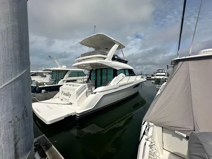 Finally Yacht Photos Pics 2021 Tiara Yachts F44 Flybridge docked at marina under cloudy sky.