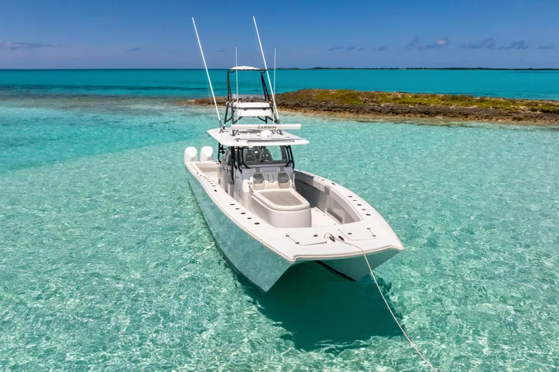 Reel Deal Yacht Photos Pics 2023 Freeman 42 LR boat anchored in clear turquoise waters near a small island.