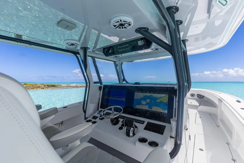 Reel Deal Yacht Photos Pics 2023 Freeman 42 LR boat cockpit with advanced navigation system, overlooking clear blue waters.