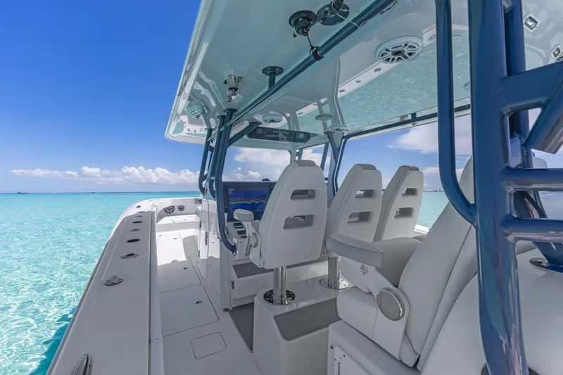 Reel Deal Yacht Photos Pics 2023 Freeman 42 LR boat interior with white seating, blue ocean backdrop.