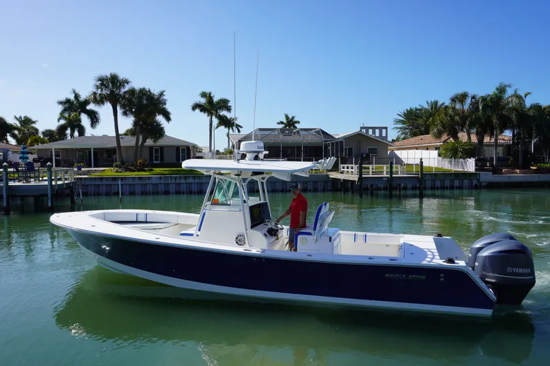 Knot Letting Go Yacht Photos Pics 2005 Regulator 32 boat on calm water near coastal homes.
