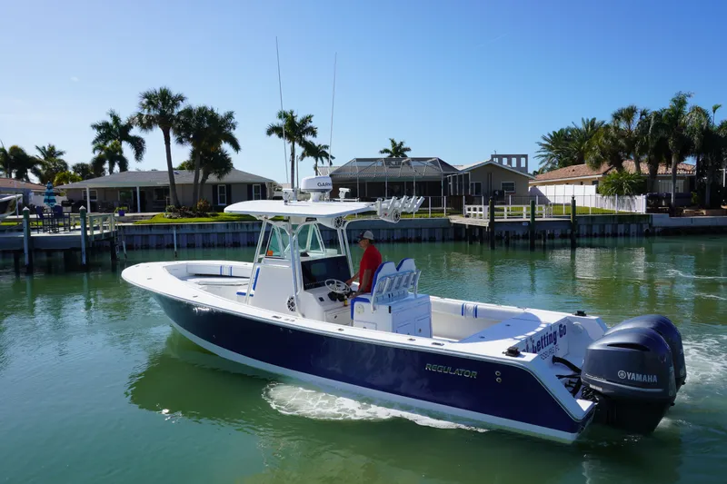Knot Letting Go Yacht Photos Pics 2005 Regulator 32 boat on calm water with palm trees.