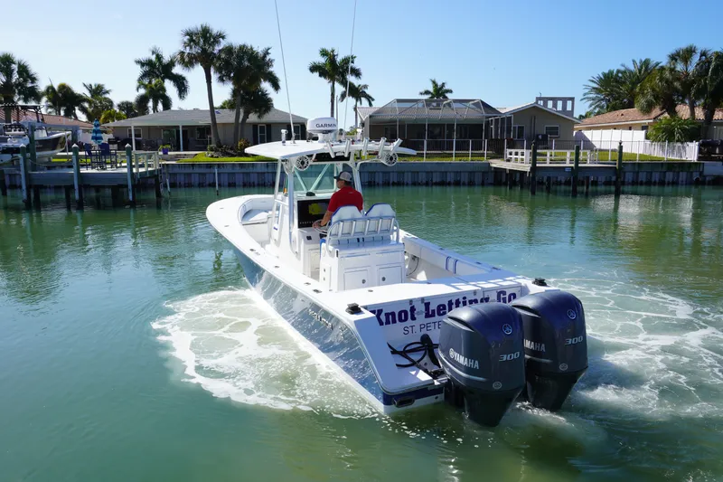 Knot Letting Go Yacht Photos Pics 2005 Regulator 32 boat on calm water with palm trees in the background.