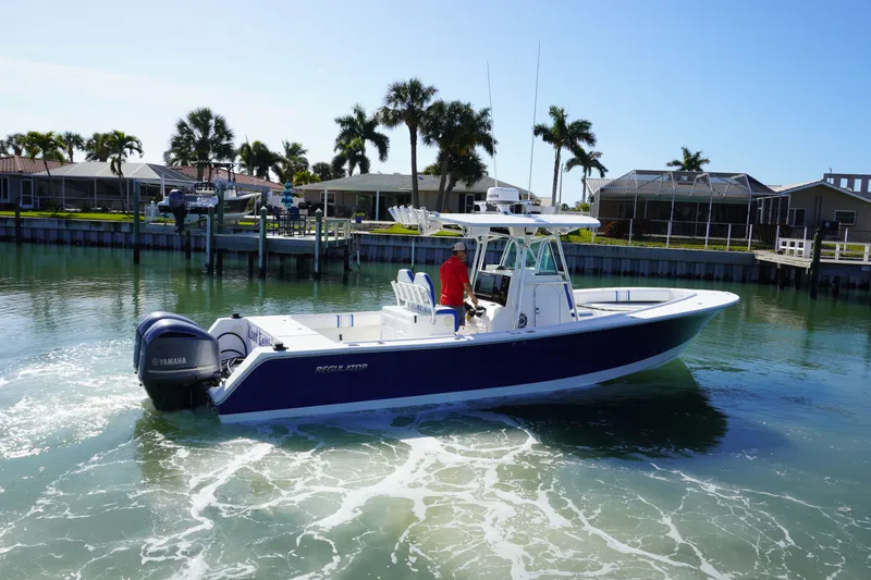 Knot Letting Go Yacht Photos Pics 2005 Regulator 32 boat on calm water with palm trees in background.