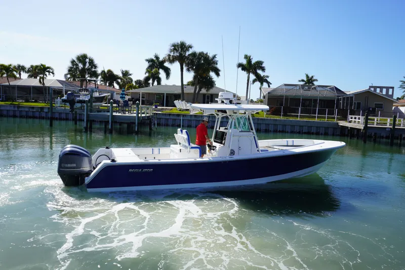 Knot Letting Go Yacht Photos Pics 2005 Regulator 32 boat on calm water with palm trees in background.