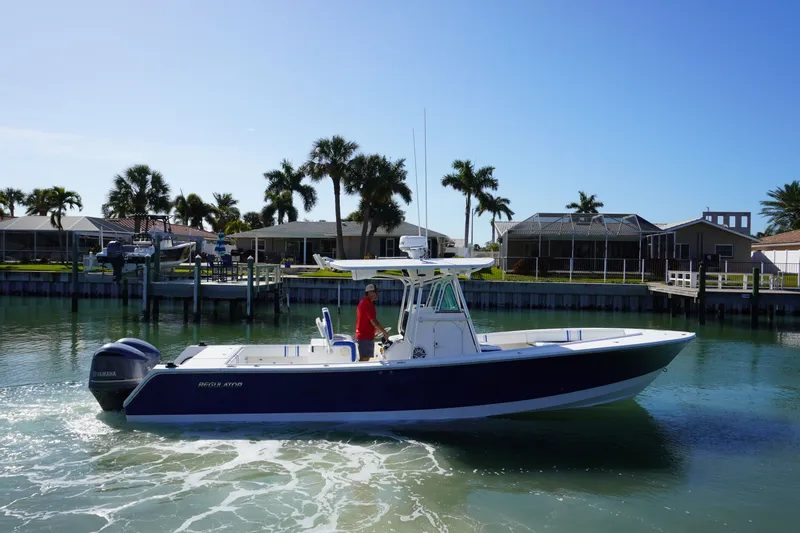 Knot Letting Go Yacht Photos Pics 2005 Regulator 32 boat on calm water with palm trees.