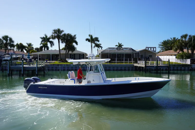 Knot Letting Go Yacht Photos Pics 2005 Regulator 32 boat on calm water near coastal homes.