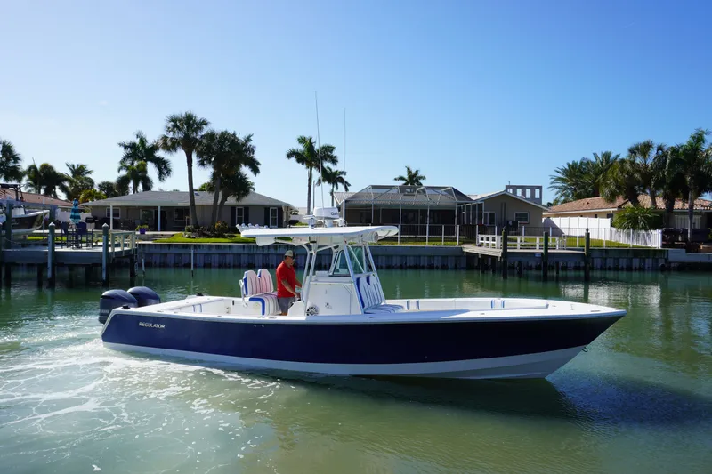 Knot Letting Go Yacht Photos Pics 2005 Regulator 32 boat on calm water near coastal homes.
