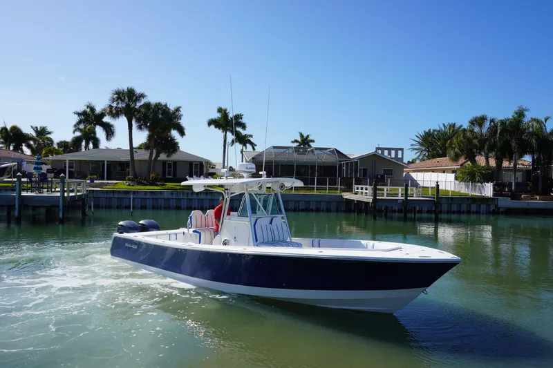 Knot Letting Go Yacht Photos Pics 2005 Regulator 32 boat on calm water near houses.