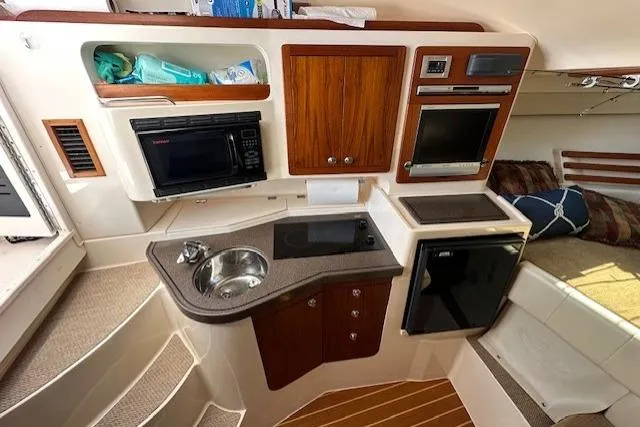  Yacht Photos Pics 2008 Grady-White Express 330 boat interior with kitchenette, featuring sink, microwave, and compact fridge.