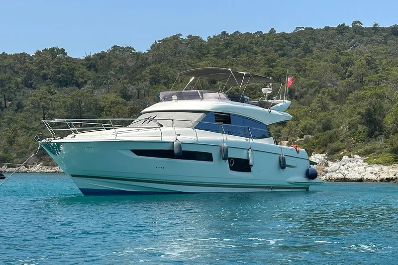 Lt Yacht Photos Pics 2016 Prestige 550 yacht anchored in clear blue water near a forested shoreline.