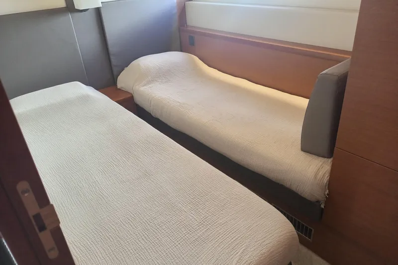 Lt Yacht Photos Pics Twin beds in a 2016 Prestige 550 yacht cabin, featuring modern design and neutral tones.