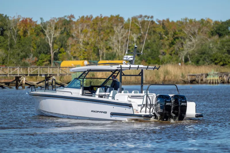  Yacht Photos Pics 2022 Axopar 37 Sun Top boat cruising on a river with scenic background.