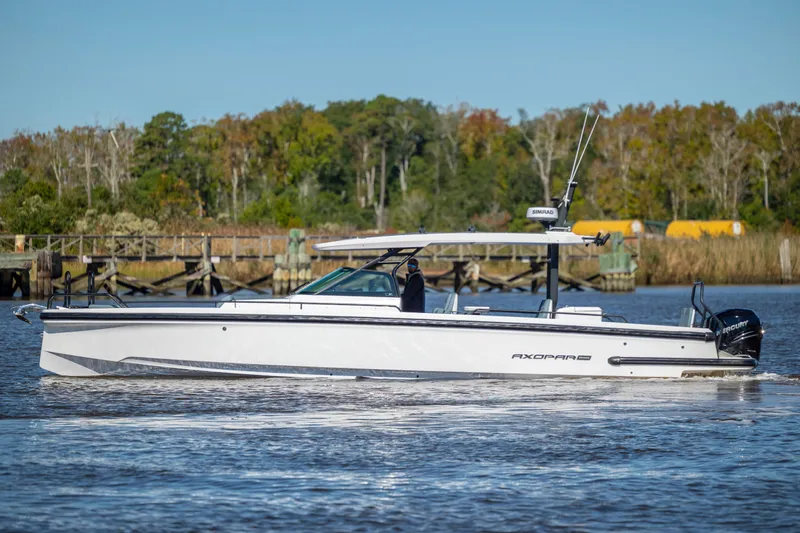  Yacht Photos Pics 2022 Axopar 37 Sun Top boat cruising on a calm river with a scenic background.