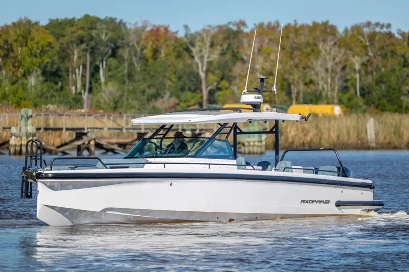  Yacht Photos Pics 2022 Axopar 37 Sun Top boat cruising on a calm river with lush greenery background.