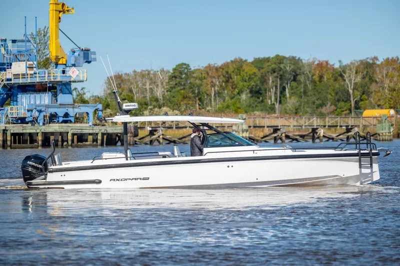  Yacht Photos Pics 2022 Axopar 37 Sun Top boat cruising on a river near industrial dock.