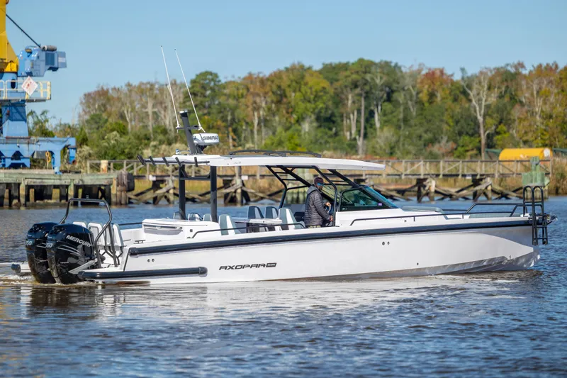  Yacht Photos Pics 2022 Axopar 37 Sun Top boat cruising on a river with scenic background.