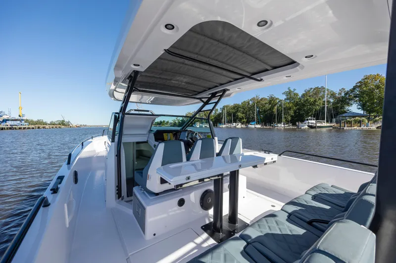  Yacht Photos Pics 2022 Axopar 37 Sun Top boat interior with seating and table on a sunny day.