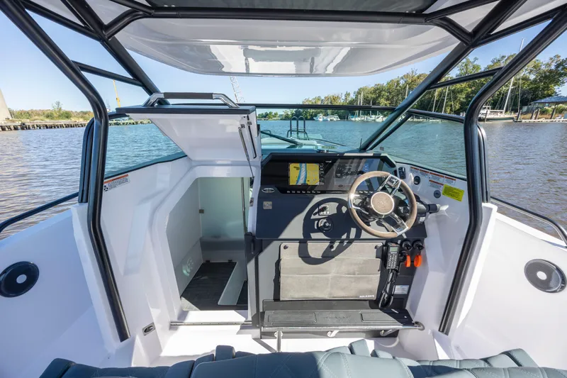  Yacht Photos Pics 2022 Axopar 37 Sun Top boat interior with steering wheel and navigation system.